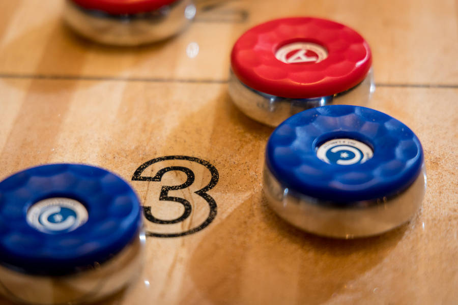 Competing In Shuffleboard - A Close-up Shot Of A Number Three Scoring Puck. Wallpaper