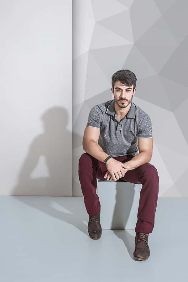 Confident Male Model Posing Against Abstract Gray Wall Wallpaper