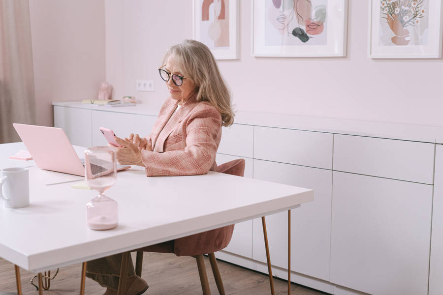 Confident Mature Woman In Pink Office Wallpaper