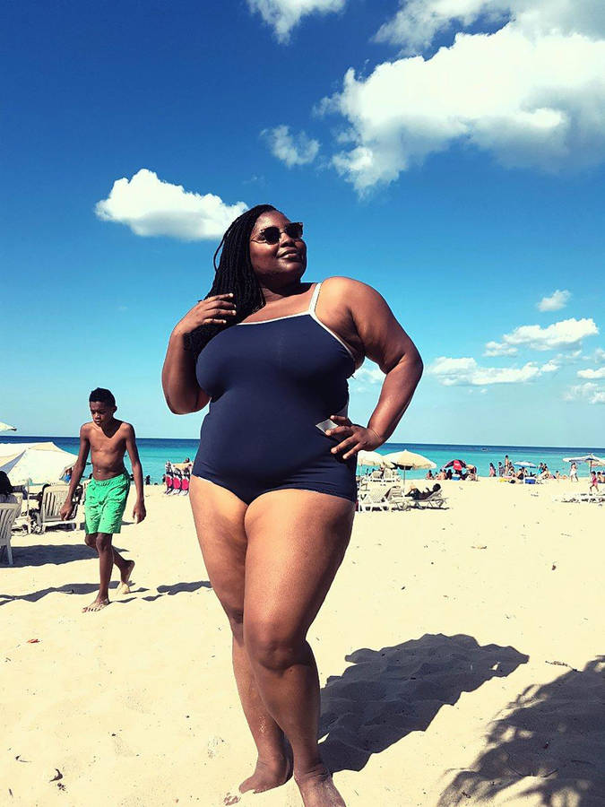 Confident Plus-sized Black Woman In Swimsuit Wallpaper