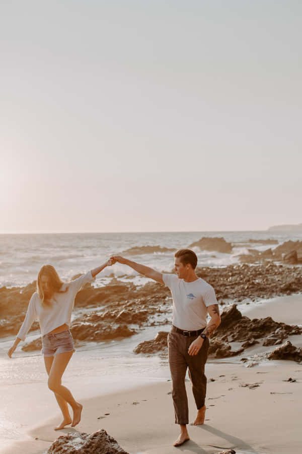 Couple At Beach In Laguna California Holding Hands Wallpaper