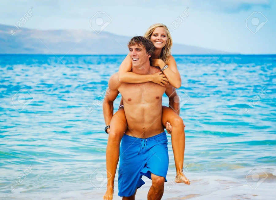 Couple At Beach Piggyback Partner Wallpaper