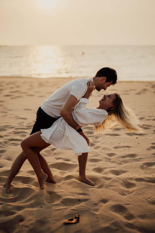 Couple At Beach Playful Pose Wallpaper