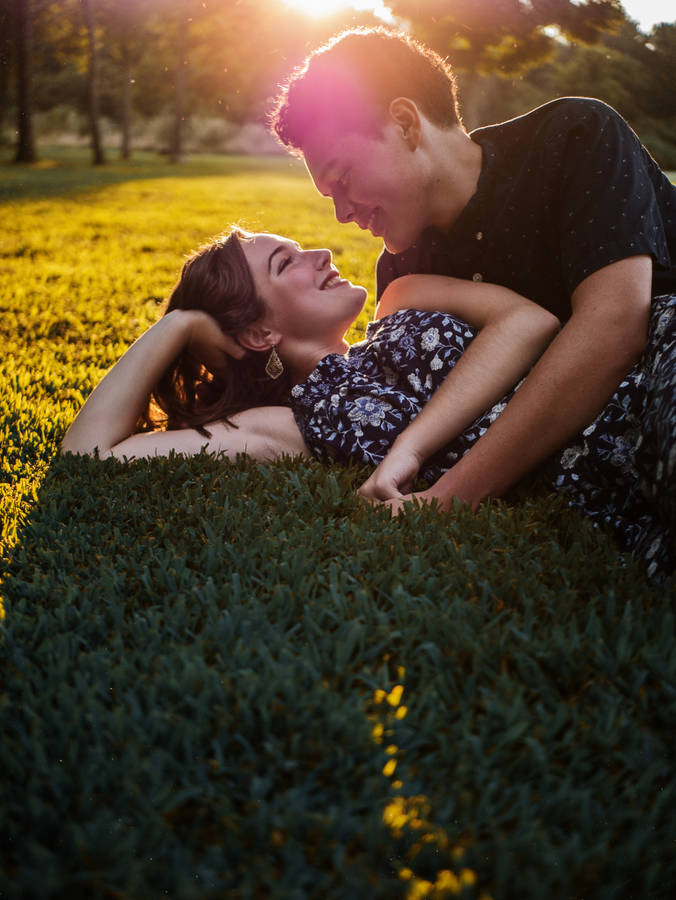 Couple Laying On Grass Wallpaper