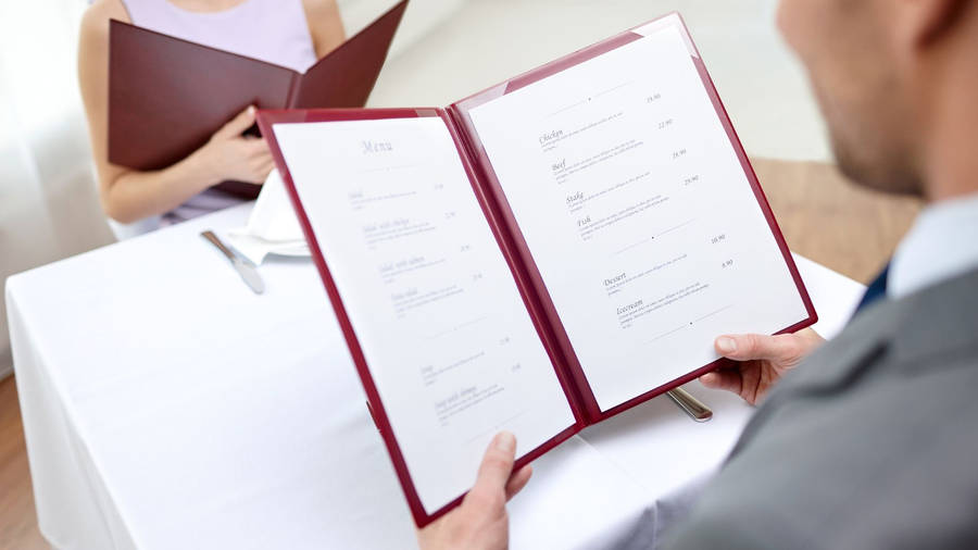 Couples Ordering From Menu In Restaurant Photography Wallpaper