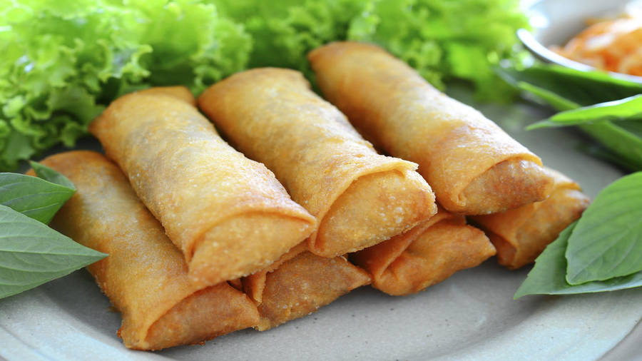 Crispy Egg Rolls Stacked Elegantly With Fresh Lettuce Garnish Wallpaper