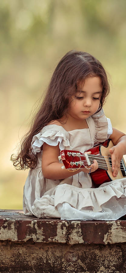 Cute Baby Girl Playing Guitar Wallpaper