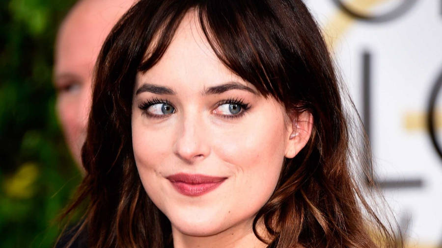 Dakota Johnson Captivatingly Poised In A Candid Portrait Wallpaper