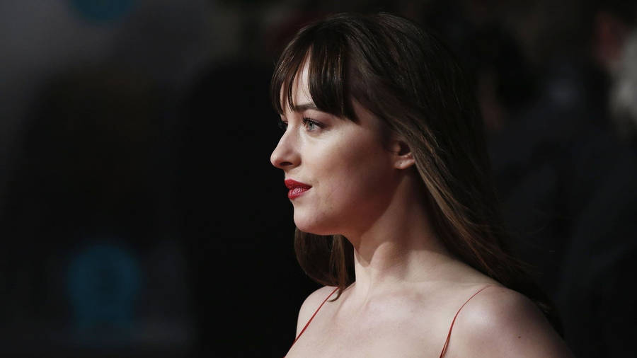 Dakota Johnson Striking Side View Wallpaper