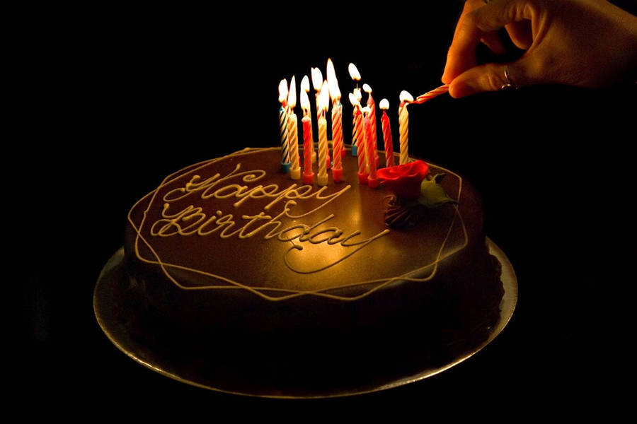 Dark Chocolate Birthday Cake Adorned With Lit Candles Wallpaper