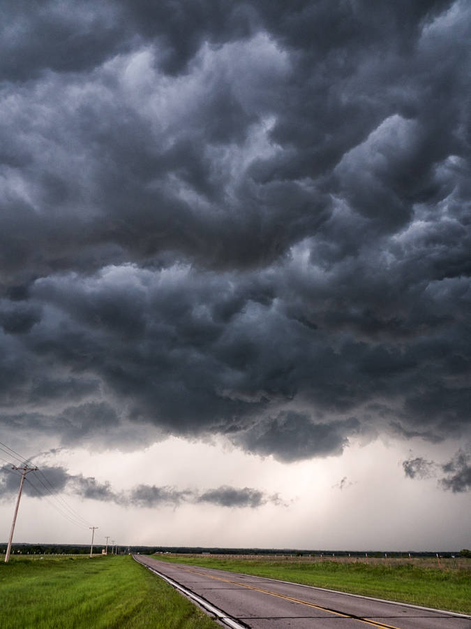 Dark Cloudy Sky Looming Storm Over Road Wallpaper