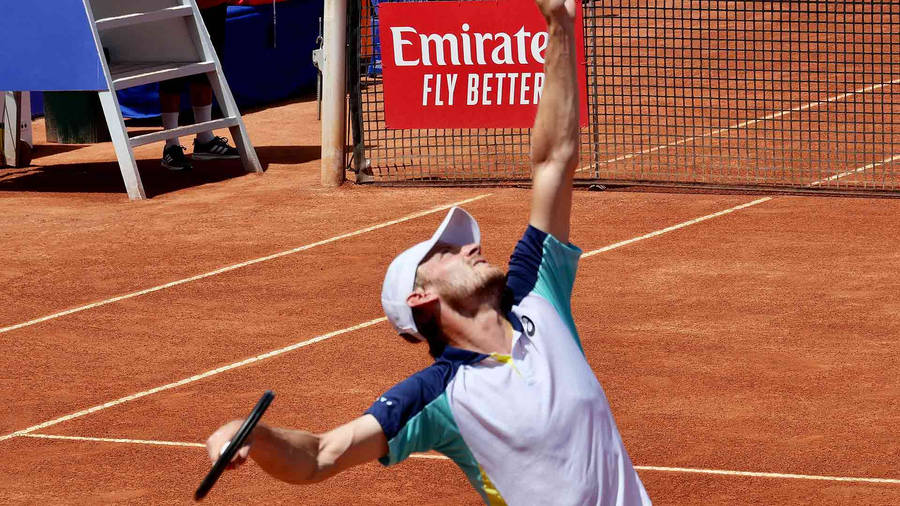 David Goffin Demonstrating A Powerful Serve In Action Wallpaper