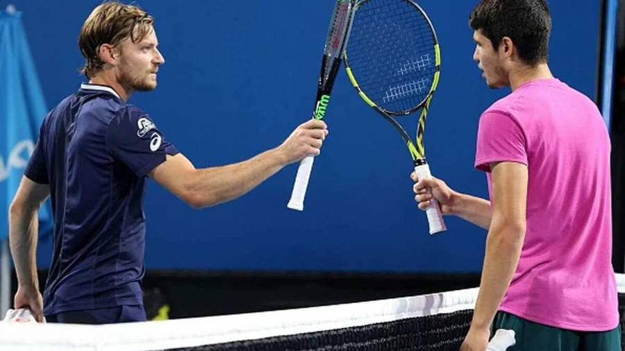 David Goffin In Action Against Carlos Alcaraz During A Tennis Match. Wallpaper