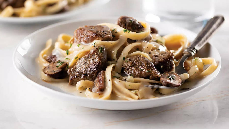 Delectable Beef Stroganoff Served Over Linguine Pasta Wallpaper