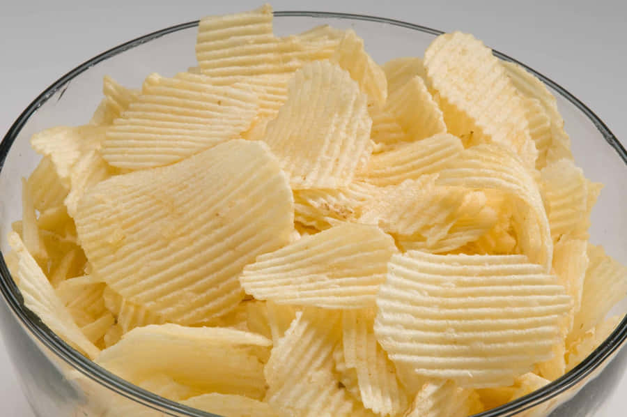 Delectable, Crunchy Potato Chips In A Glass Bowl Wallpaper