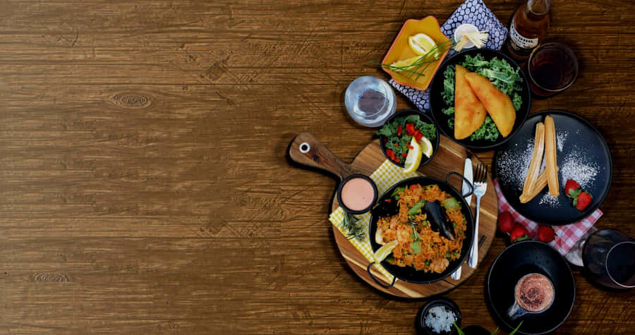 Delicious Dining Experience With A Friends & Family Food Table Wallpaper