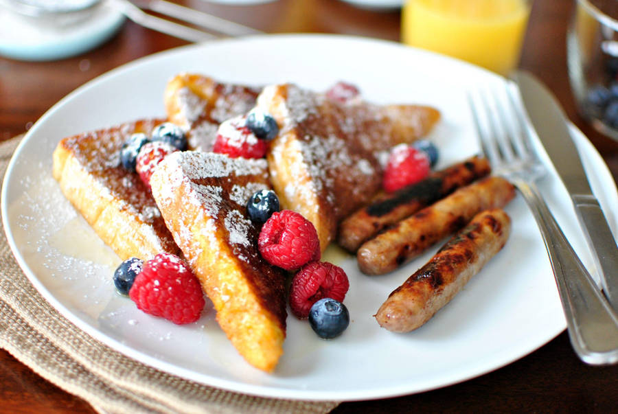 Delicious Homemade French Toast With Fresh Berries And Maple Syrup Wallpaper