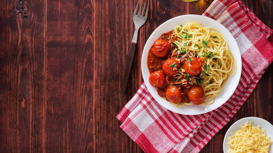 Delicious Spaghetti Pasta Tossed With Fresh Tomatoes Wallpaper