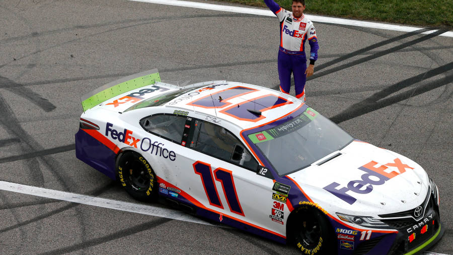 Denny Hamlin Poses Next To His Racing Car Wallpaper