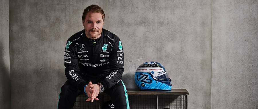 Determined Valtteri Bottas Sitting With His Racing Helmet Wallpaper