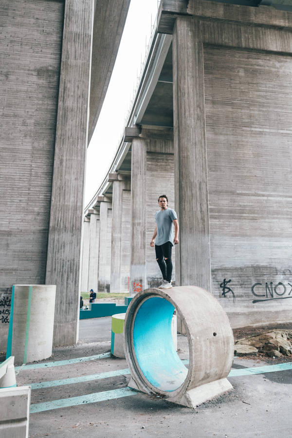 Determined Young Man Embracing His Courage In A Concrete Jungle Wallpaper