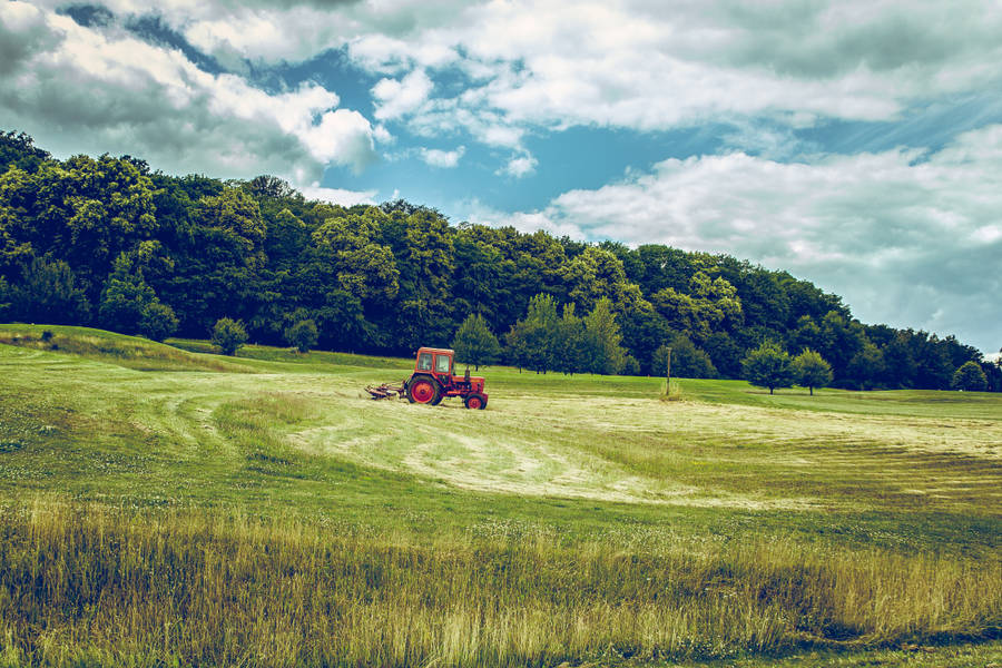 Distant Tractor On The Field Wallpaper