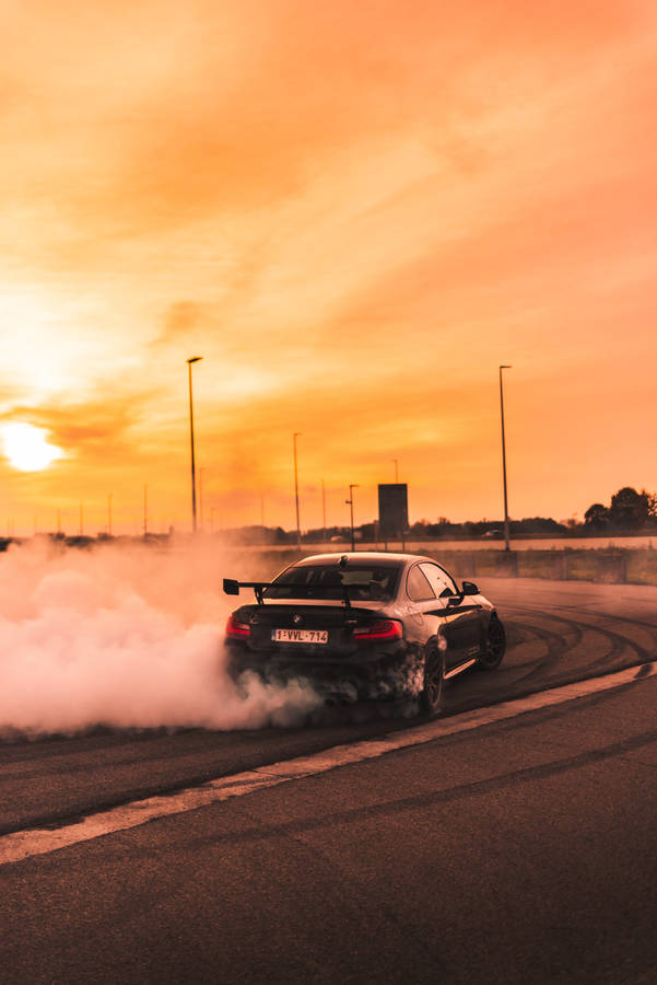 Drift Car In Action Under A Golden Sky Wallpaper