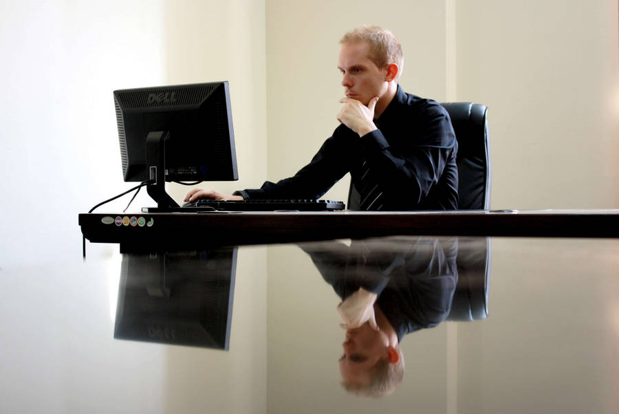 Dynamic Entrepreneur Crafting Success In His Office Wallpaper