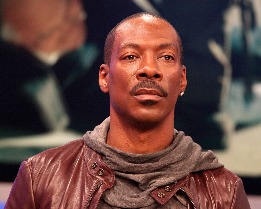 Eddie Murphy Looking Suave In A Brown Leather Jacket Wallpaper