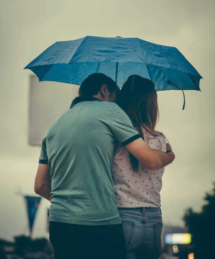 Embrace Of Love Under An Umbrella Wallpaper