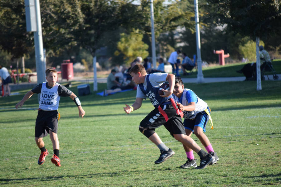 Energetic Young Players In An Exciting Flag Football Match Wallpaper