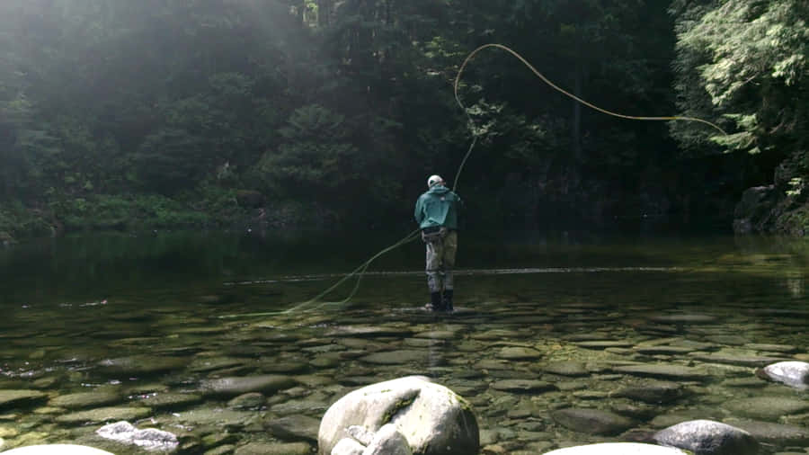 Enjoying A Beautiful Day Of Fly Fishing Wallpaper