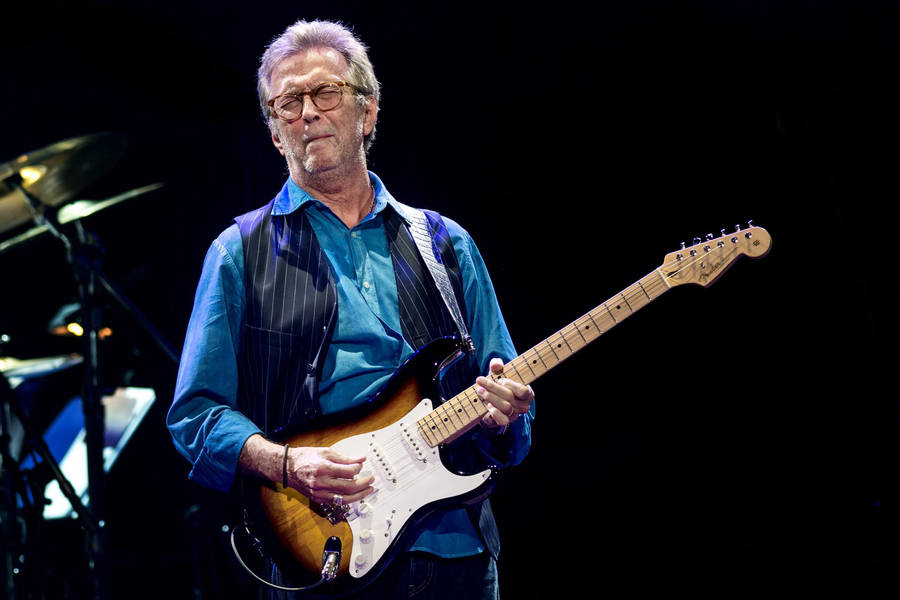 Eric Clapton Striking A Pose In His Signature Blue Polo Wallpaper