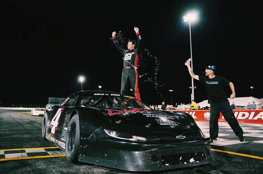 Erik Jones Above His Black Car Wallpaper