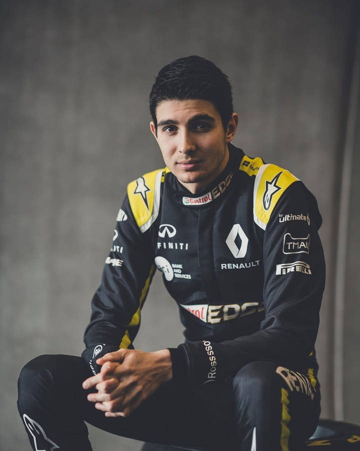 Esteban Ocon With Confident Pose Against Gray Backdrop Wallpaper