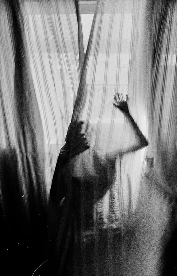 Ethereal Figure Behind Curtains Wallpaper