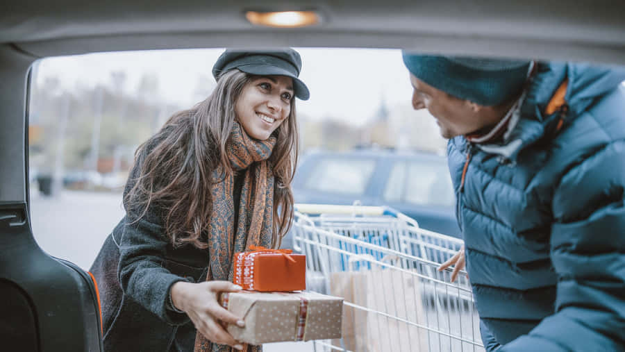 Excited Shopper Carrying Boxes During Boxing Day Sale Wallpaper