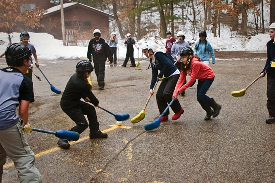 Exciting Family Broomball Match In Action Wallpaper