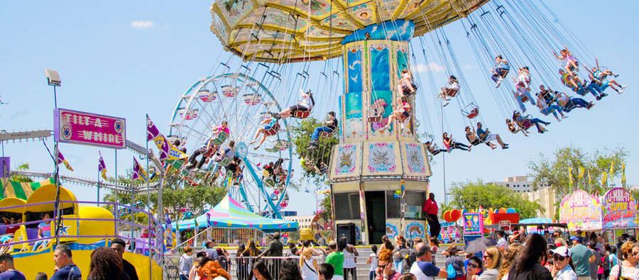 Exciting Tilt-a-whirl Ride At A Vibrant Fair Wallpaper