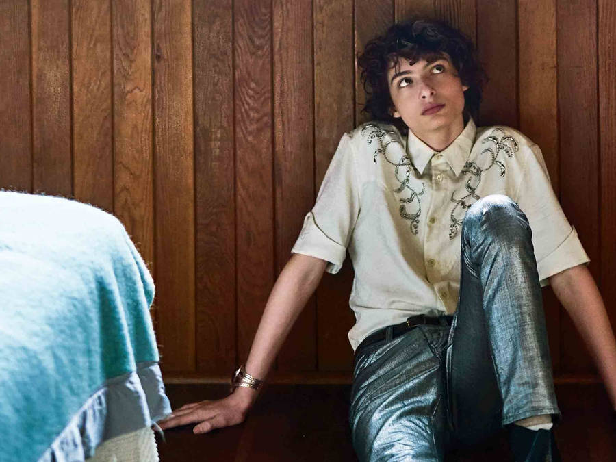 Finn Wolfhard On Floor Wallpaper