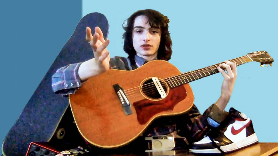 Finn Wolfhard With Guitar Wallpaper