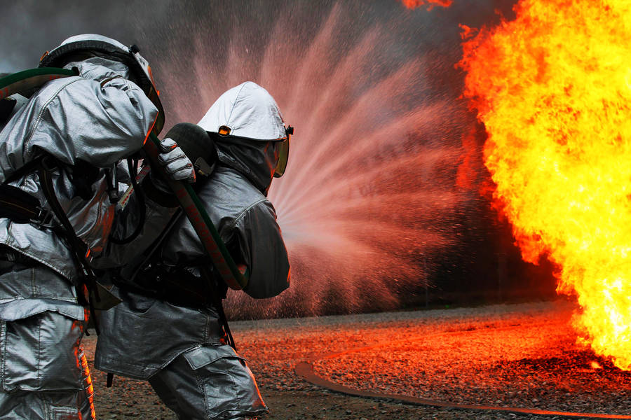 Firefighter Unleashing A Powerful Water Blast Wallpaper