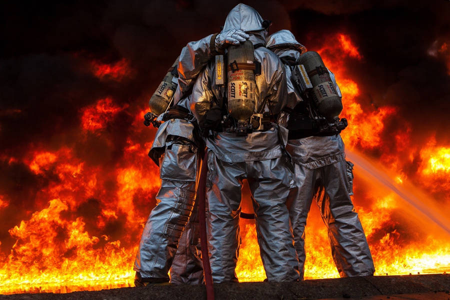 Fireman With His Team Against A Fire Wallpaper