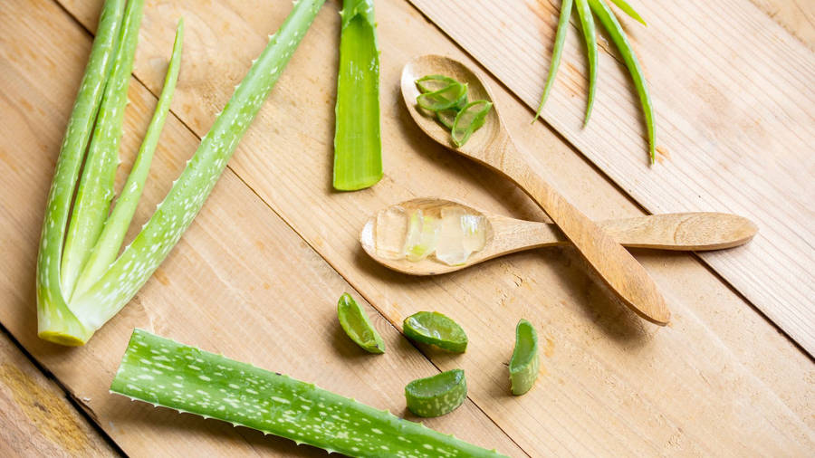 Fresh Aloe Vera Gel With Slices In A Wooden Spoon Wallpaper