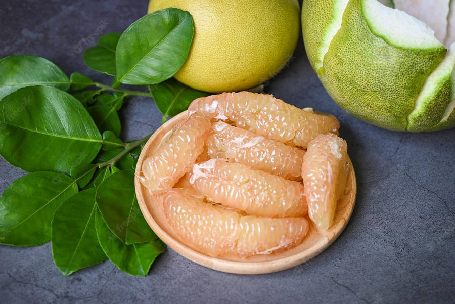 Fresh Pomelo On Wooden Table Wallpaper