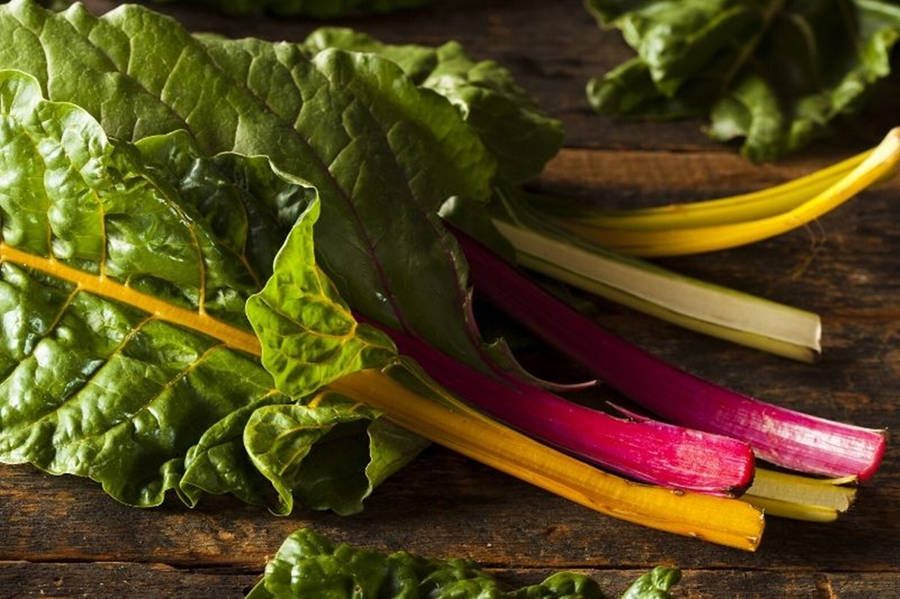 Fresh Swiss Chard On Rustic Wooden Table Wallpaper