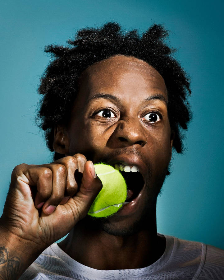 Gael Monfils Biting A Tennis Ball Wallpaper