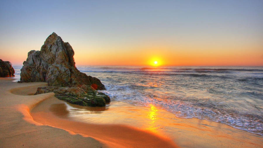 Giant Rock Formation On Beach Sunset Wallpaper