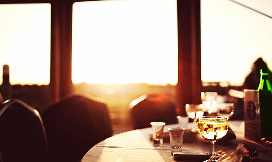 Glasses On Restaurant Table During Golden Hour Wallpaper