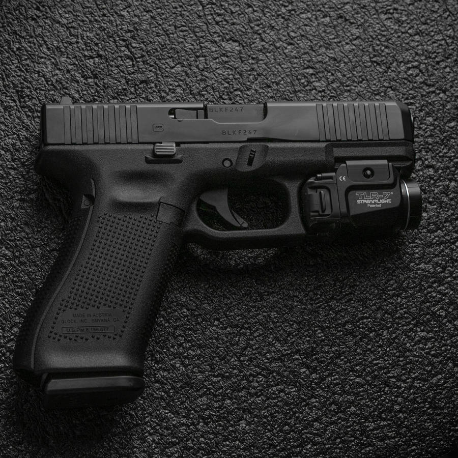 Glock On Black Concrete Surface Wallpaper